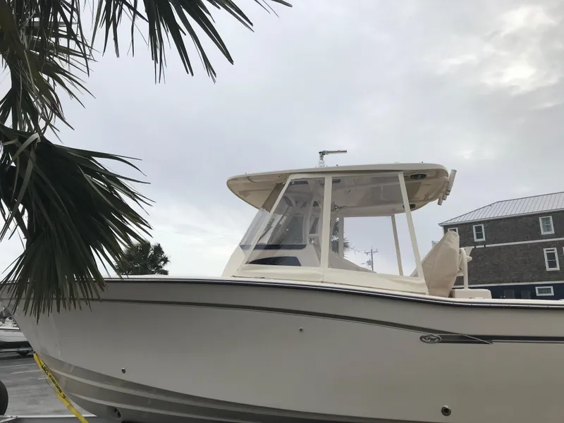 Slide: The Image of 2019 Grady-White Canyon 306 boat docked near palm tree under cloudy sky. - 35