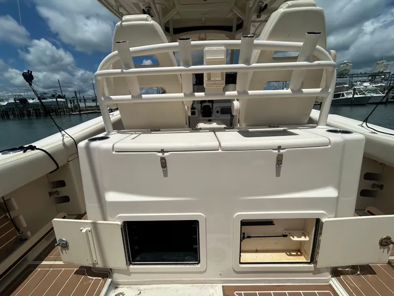 Slide: The Image of 2019 Grady-White Canyon 306 boat interior with storage compartments open, docked under a cloudy sky. - 5