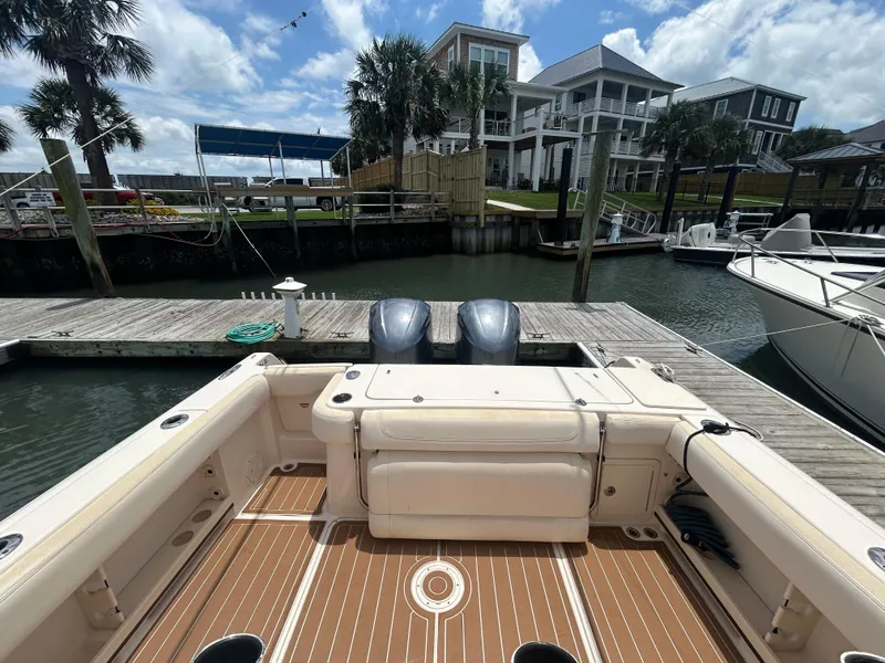 Slide: The Image of 2019 Grady-White Canyon 306 boat docked, featuring dual engines and spacious deck. - 6