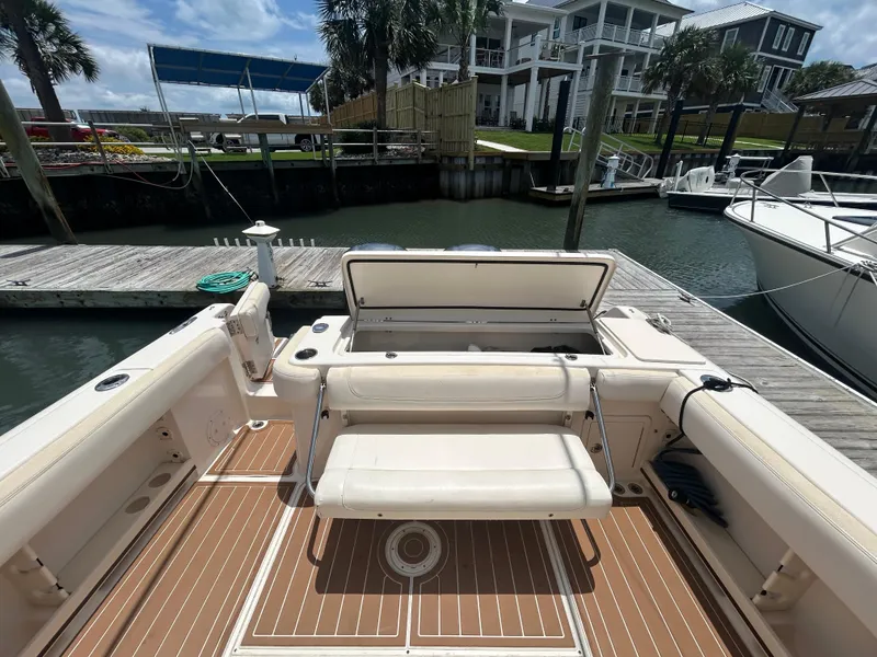 Slide: The Image of 2019 Grady-White Canyon 306 boat interior at dock, featuring seating and storage. - 7