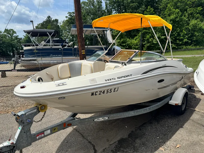 Slide: The Image of 2008 Sea Ray 185 Sport boat with yellow canopy on trailer, parked outdoors. - 4