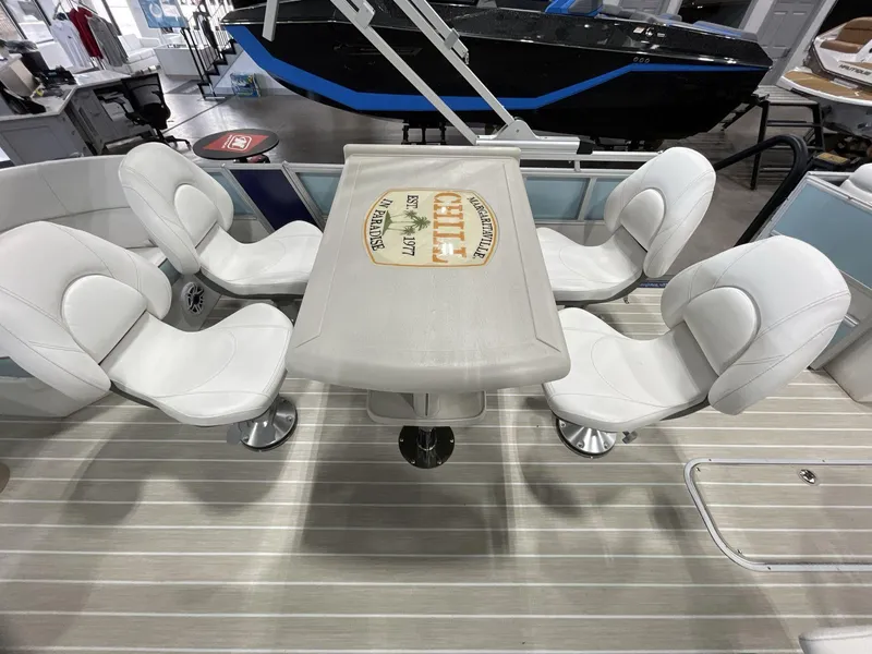 Slide: The Image of 2025 South Bay S224 Chill boat interior with white seating and table. - 18