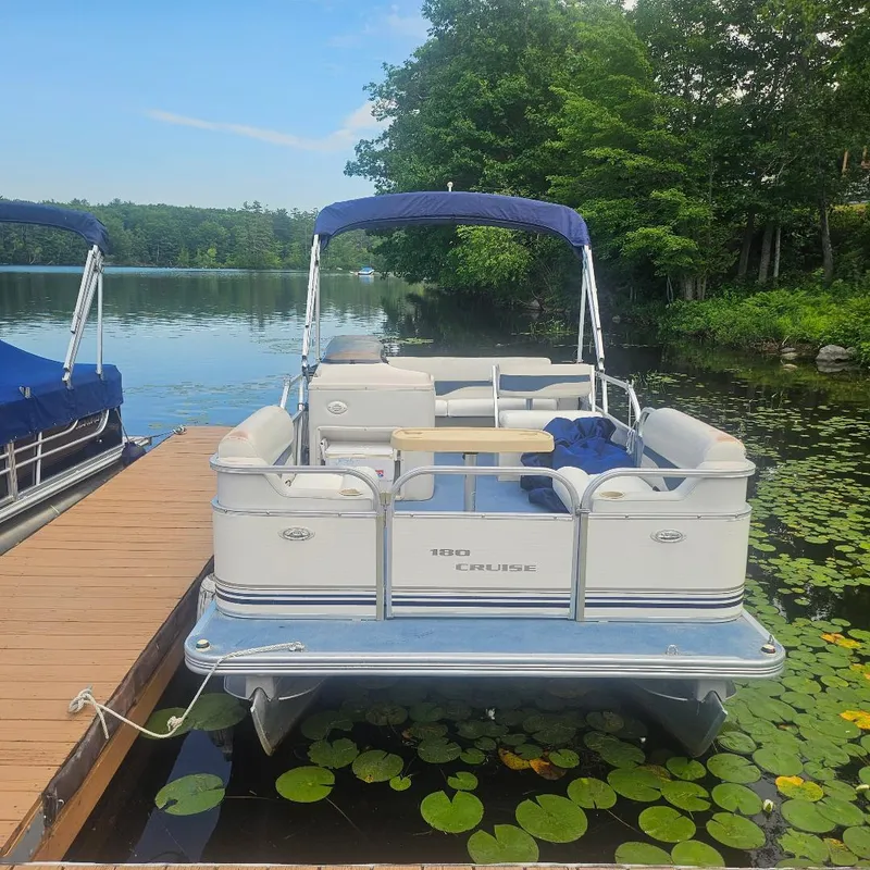 Slide: The Image of 2003 Starcraft Cruise 180 pontoon boat docked on a serene lake with lily pads. - 3