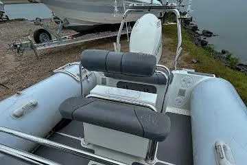 Slide: The Image of 2014 Sealegs 7.1m RIB with gray seating, docked near water. - 11