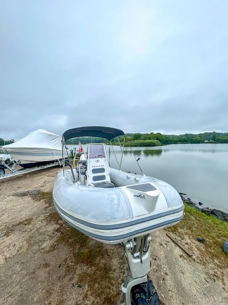 Slide: The Image of 2014 Sealegs 7.1m RIB boat on shore near a calm lake. - 4