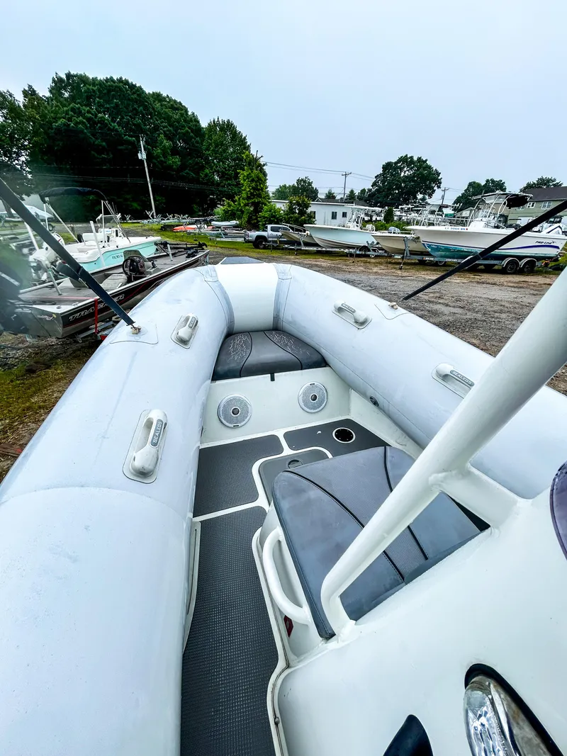 Slide: The Image of 2014 Sealegs 7.1m RIB boat with gray seating, parked outdoors. - 7
