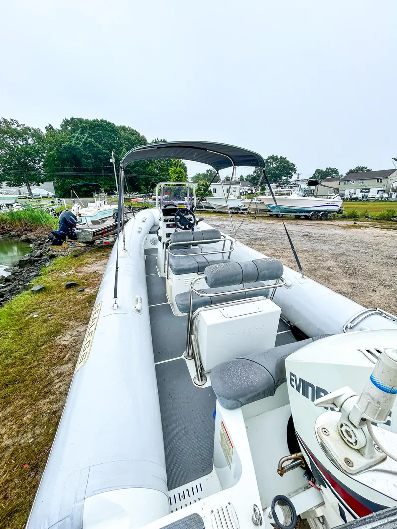 Slide: The Image of 2014 Sealegs 7.1m RIB with Evinrude motor, parked on grassy shore. - 9