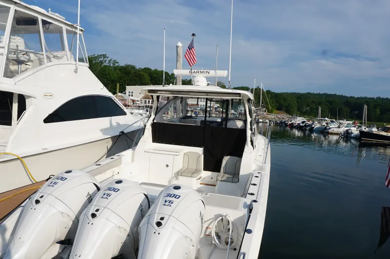 Slide: The Image of 2023 Pursuit OS 355 Offshore boat docked with triple 300 V6 engines. - 12