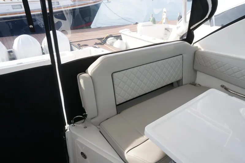 Slide: The Image of 2023 Pursuit OS 355 Offshore boat interior with cushioned seating and table. - 15