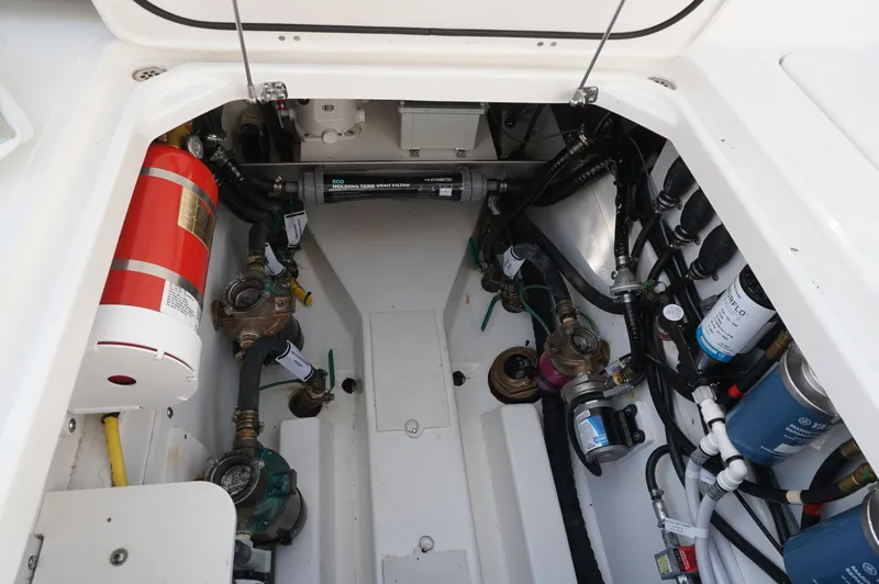 Slide: The Image of 2023 Pursuit OS 355 Offshore engine compartment with fire extinguisher and various mechanical components. - 20