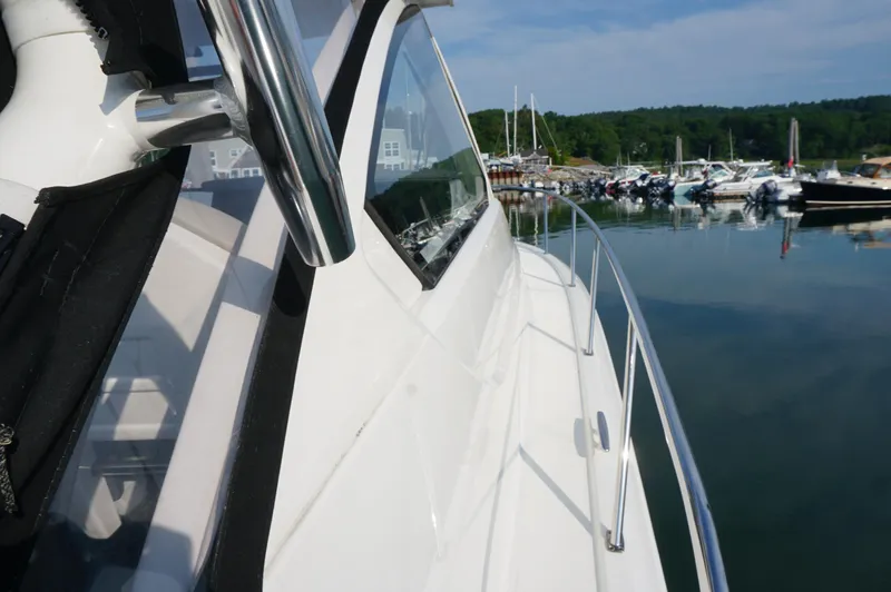 Slide: The Image of 2023 Pursuit OS 355 Offshore boat docked in a serene marina setting. - 22