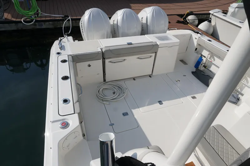 Slide: The Image of 2023 Pursuit OS 355 Offshore boat deck with triple outboard engines. - 26