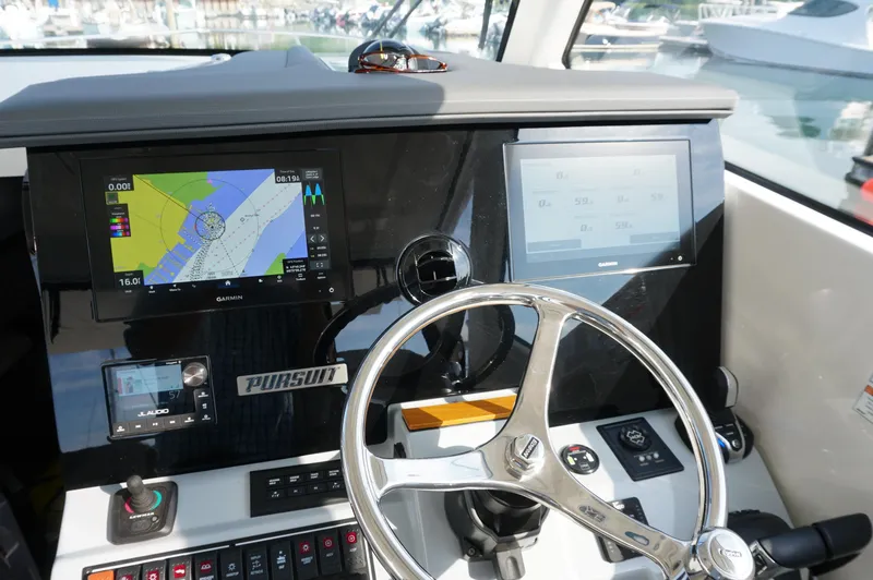Slide: The Image of 2023 Pursuit OS 355 Offshore helm with Garmin displays and steering wheel. - 27