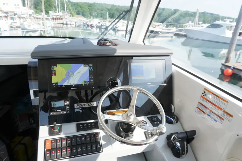 Slide: The Image of Helm of 2023 Pursuit OS 355 Offshore boat with navigation screens and controls. - 29