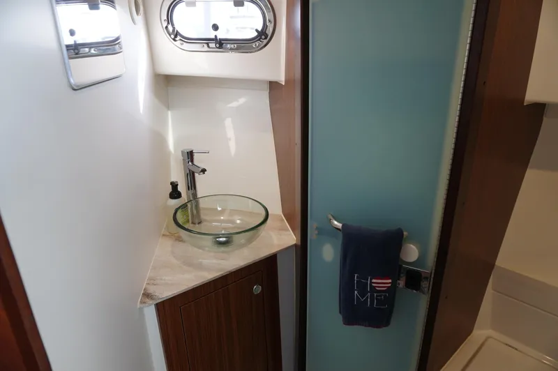 Slide: The Image of 2023 Pursuit OS 355 Offshore bathroom with glass sink and modern fixtures. - 30