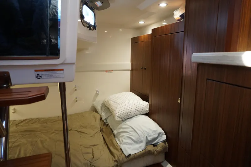 Slide: The Image of 2023 Pursuit OS 355 Offshore cabin interior with bed and wooden cabinetry. - 35