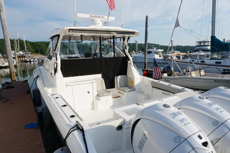 Slide: The Image of 2023 Pursuit OS 355 Offshore boat docked at marina with triple Yamaha engines. - 4