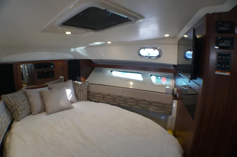 Slide: The Image of 2023 Pursuit OS 355 Offshore cabin interior with bed, pillows, and porthole window. - 47