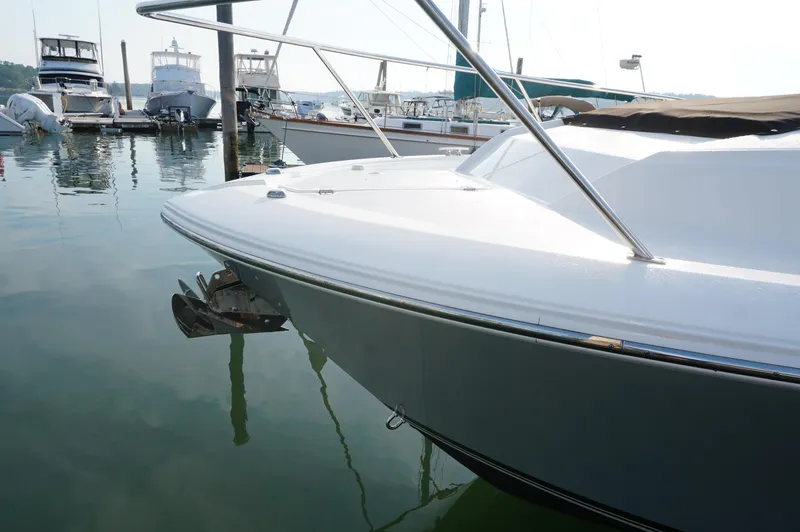 Slide: The Image of 2023 Pursuit OS 355 Offshore boat docked in a marina, reflecting on calm water. - 9
