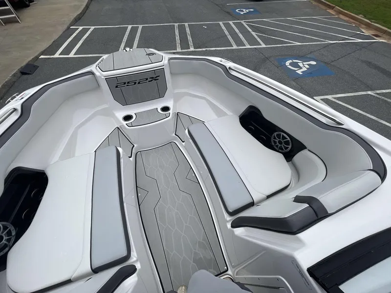 Slide: The Image of 2024 Yamaha Boats 252XE interior with sleek seating and modern design in a parking lot. - 17