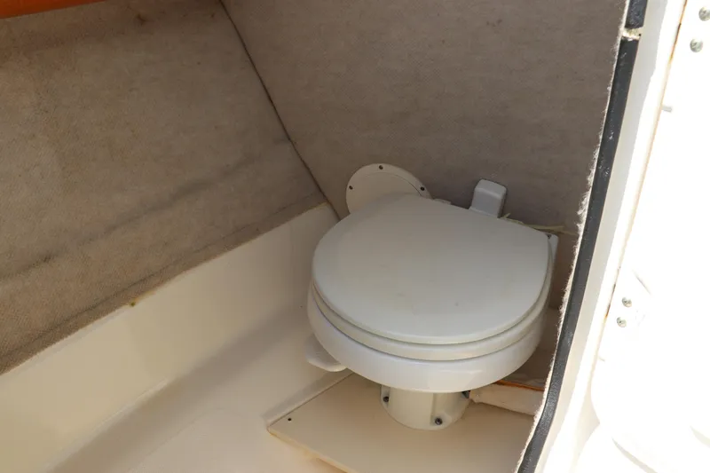 Slide: The Image of 2008 Robalo R227 Dual Console boat interior with compact marine toilet. - 23
