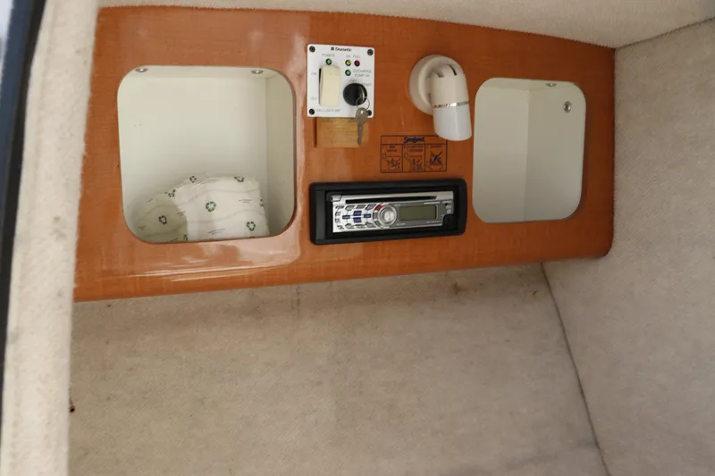 Slide: The Image of 2008 Robalo R227 Dual Console cabin interior with stereo and storage compartments. - 24