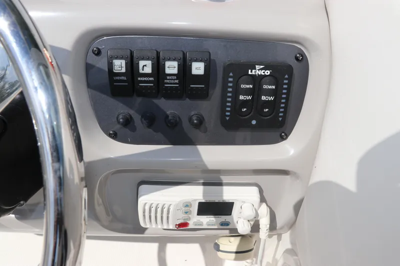 Slide: The Image of Control panel of a 2008 Robalo R227 Dual Console boat with switches and steering wheel. - 34