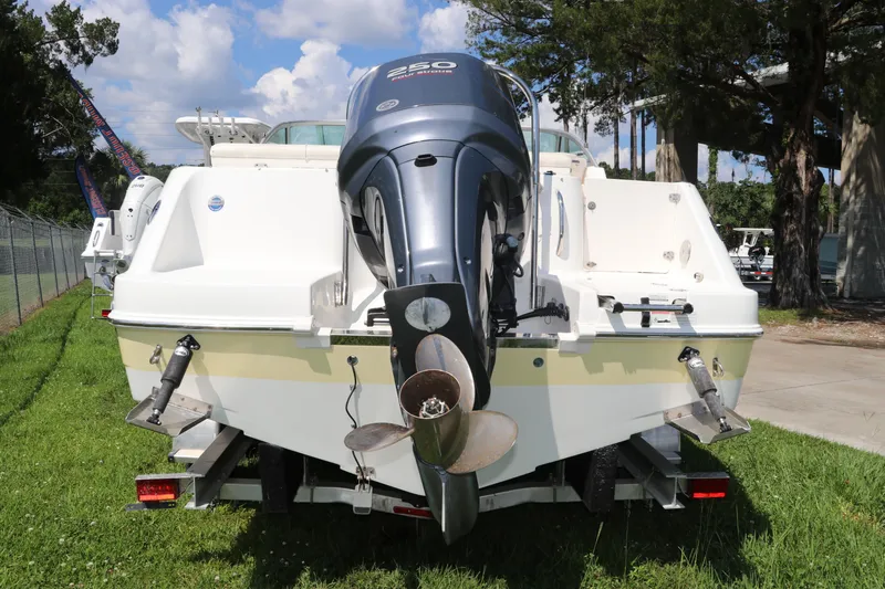 Slide: The Image of 2008 Robalo R227 Dual Console boat with outboard motor on trailer, parked on grass. - 6