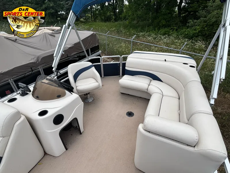 Slide: The Image of 2010 Cypress Cay 210 Seabreeze pontoon boat with white seating and blue accents. - 3