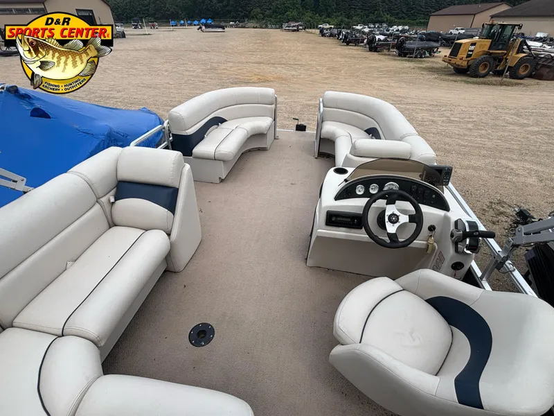 Slide: The Image of 2010 Cypress Cay 210 Seabreeze pontoon boat interior with beige seating and steering console. - 6