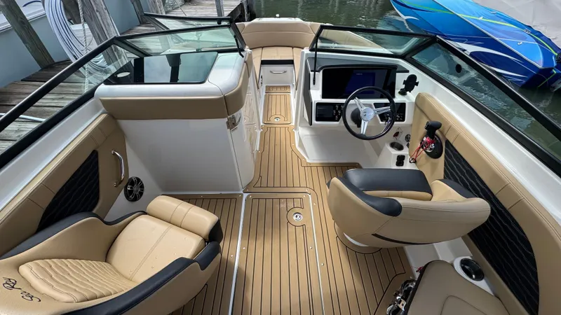 Slide: The Image of 2022 Sea Ray SPX 230 boat interior with tan seating and modern dashboard. - 10