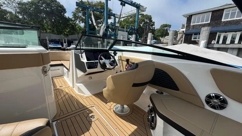 Slide: The Image of 2022 Sea Ray SPX 230 boat interior with tan seating and modern dashboard. - 11