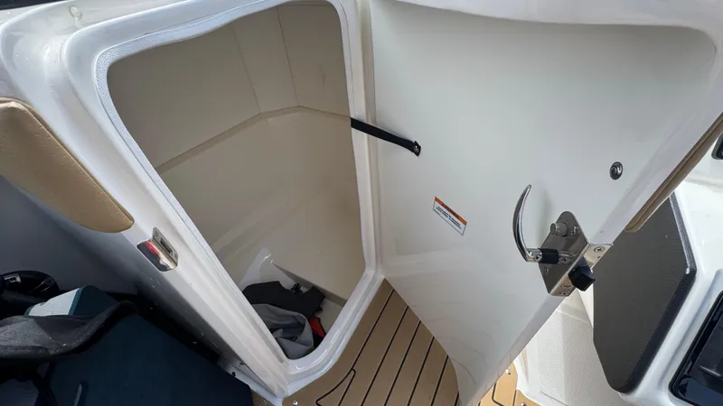 Slide: The Image of 2022 Sea Ray SPX 230 storage compartment with open door, showcasing interior space. - 14