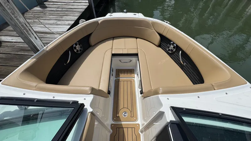 Slide: The Image of 2022 Sea Ray SPX 230 boat interior with tan seating and wood-style flooring. - 15