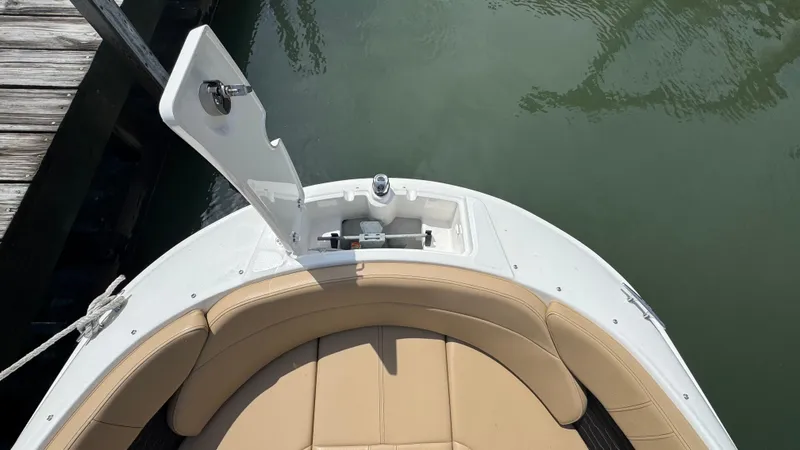 Slide: The Image of 2022 Sea Ray SPX 230 boat bow with tan seating and open storage compartment. - 16