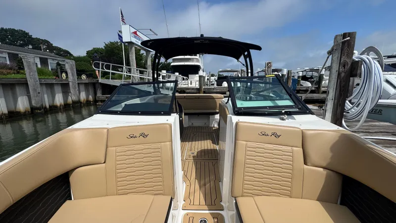 Slide: The Image of 2022 Sea Ray SPX 230 boat docked, featuring tan seating and sleek design. - 17