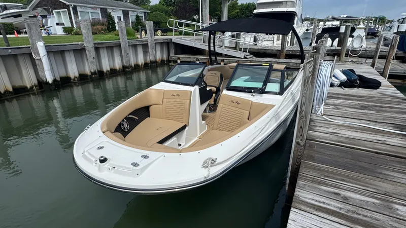 Slide: The Image of 2022 Sea Ray SPX 230 boat docked, featuring tan seating and black canopy. - 18