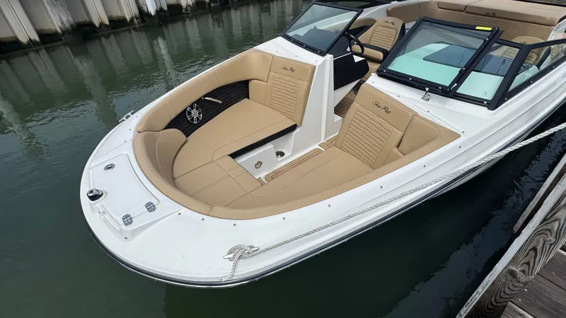 Slide: The Image of 2022 Sea Ray SPX 230 boat with beige seating, docked in calm water. - 19