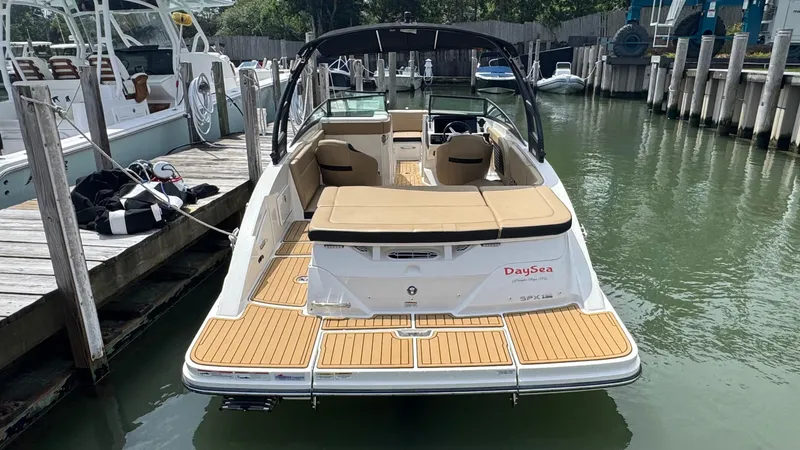 Slide: The Image of 2022 Sea Ray SPX 230 boat docked, featuring spacious seating and sleek design. - 2