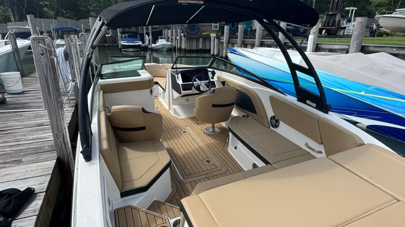 Slide: The Image of 2022 Sea Ray SPX 230 boat with tan seating and sleek design docked at marina. - 3