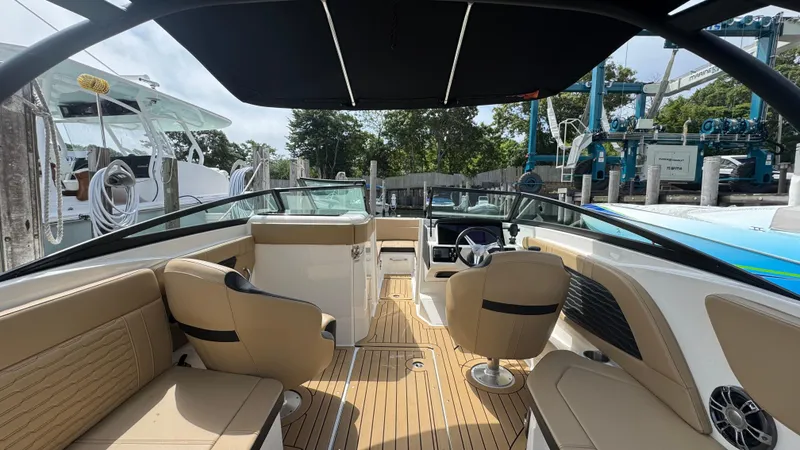 Slide: The Image of Interior view of 2022 Sea Ray SPX 230 boat with tan seating and black canopy. - 6