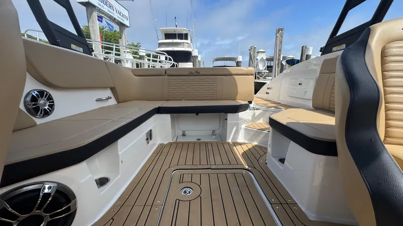 Slide: The Image of 2022 Sea Ray SPX 230 boat interior with tan seating and teak flooring. - 7