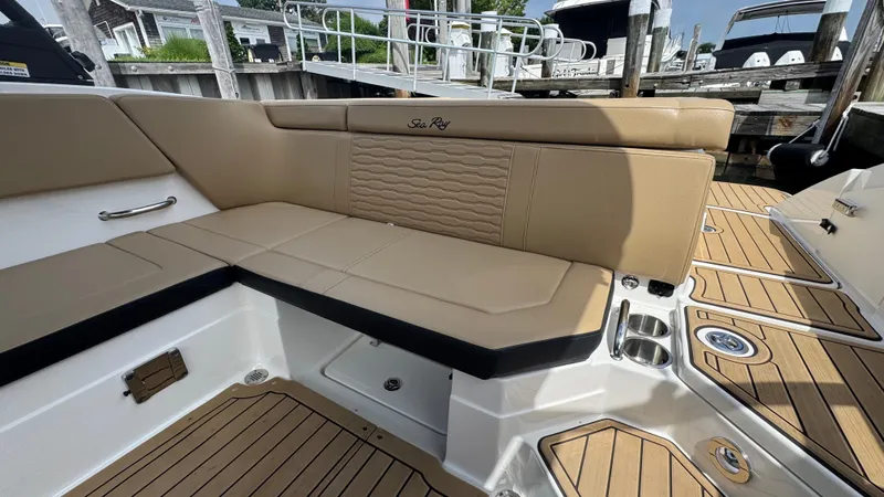 Slide: The Image of 2022 Sea Ray SPX 230 boat interior with tan seating and teak-style flooring. - 8