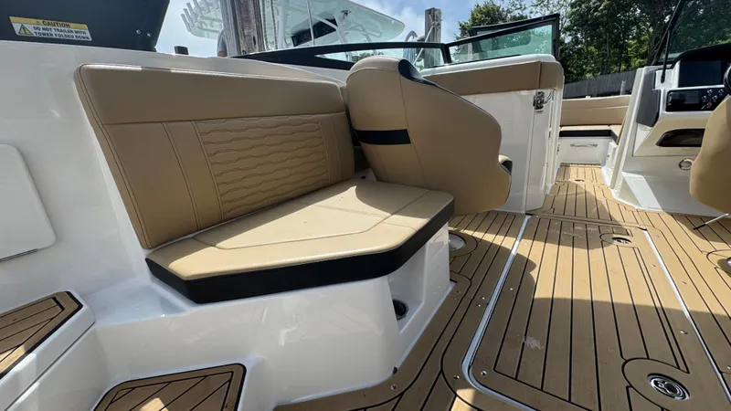 Slide: The Image of 2022 Sea Ray SPX 230 boat interior with tan seating and wood-style flooring. - 9