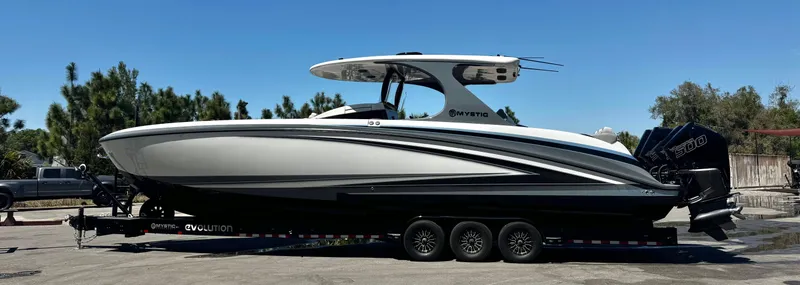 The Image of 2026 Mystic Powerboats M4200 on trailer, sleek design, parked outdoors under clear sky. - 1