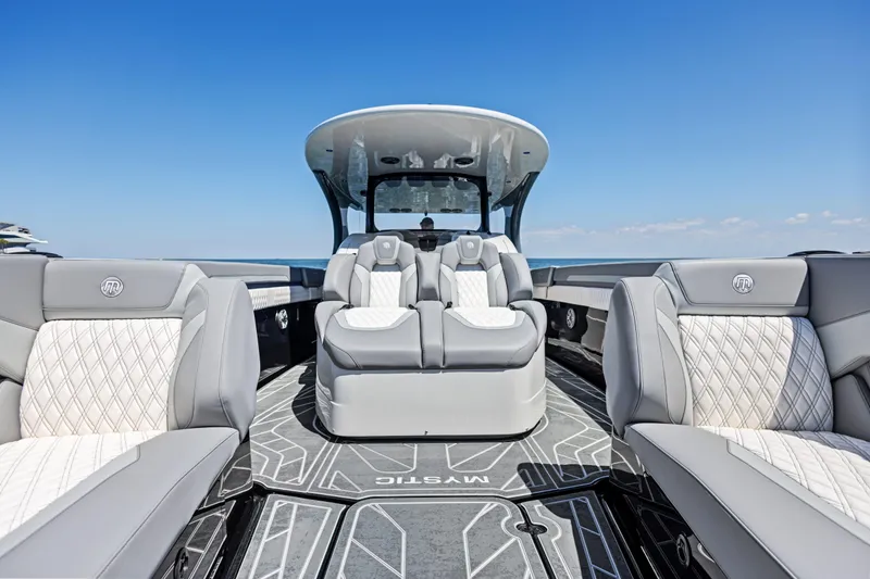 Slide: The Image of 2026 Mystic Powerboats M4200 interior with luxurious seating and sleek design under clear blue sky. - 22