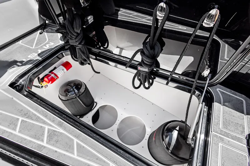 Slide: The Image of Storage compartment of 2026 Mystic Powerboats M4200 with ropes and fire extinguisher. - 23