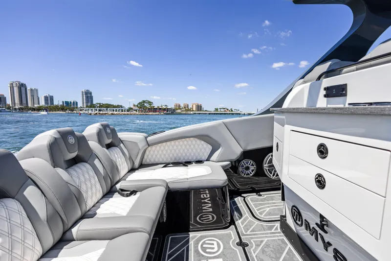 Slide: The Image of Luxurious 2026 Mystic Powerboats M4200 interior with plush seating, city skyline in background. - 26