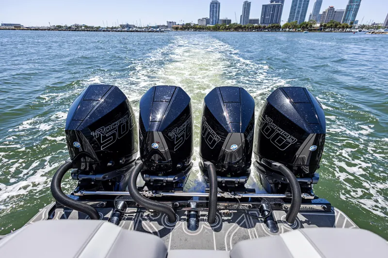Slide: The Image of Four powerful outboard engines on a 2026 Mystic Powerboats M4200, cruising near a city skyline. - 28