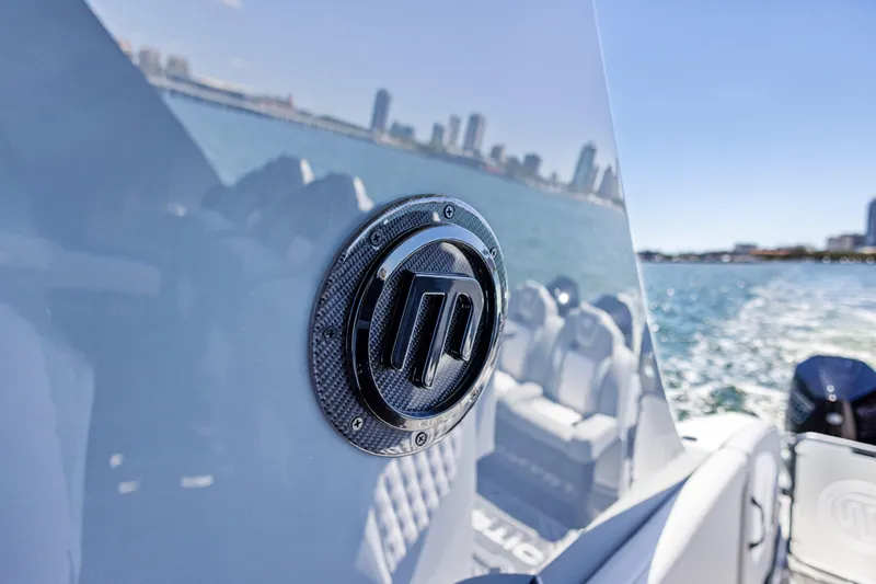 Slide: The Image of 2026 Mystic Powerboats M4200 emblem on sleek boat, city skyline in background. - 30